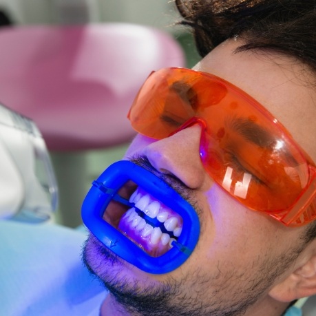 Man in dental chair getting professional teeth whitening