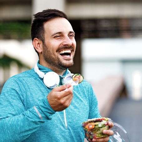 Smiling man eating a salad