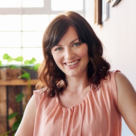 Woman in light pink sleeveless blouse smiling