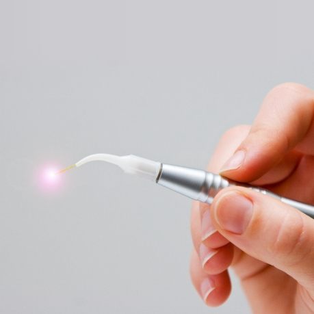 Hand holding a thin metal dental laser device