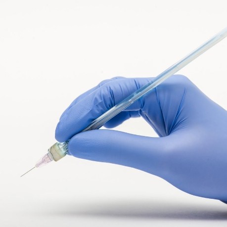 Hand holding very thin syringe and needle