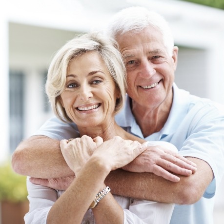 Senior man and woman hugging and smiling