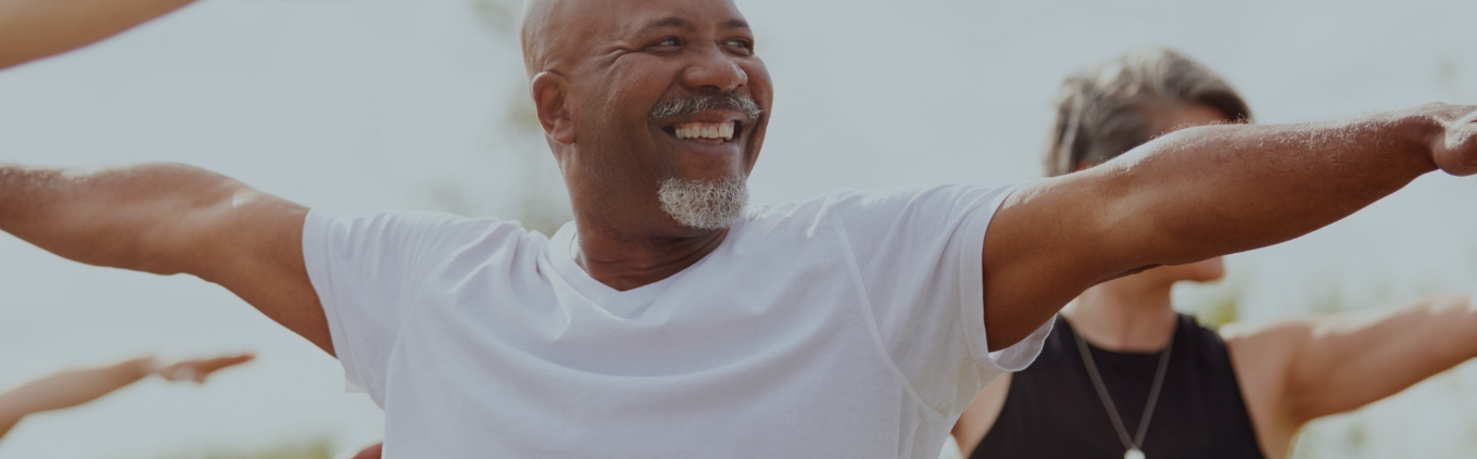 Man smiling while stretching in exercise class