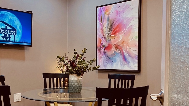 Table next to flower artwork on wall