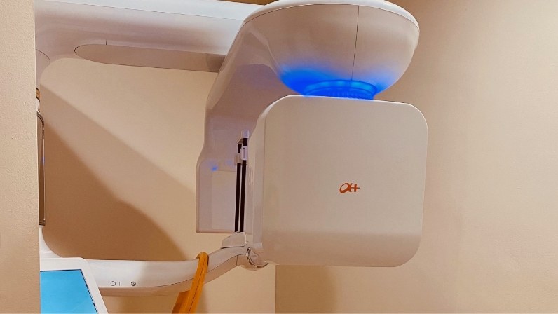 Dental cone beam scanner standing against wall