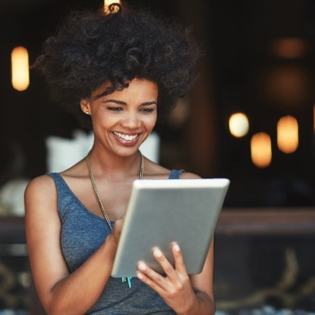 Woman smiling while using a tablet