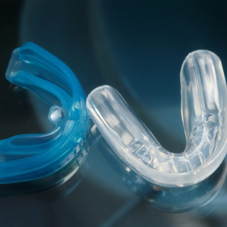 Clear oral appliance against dark blue background