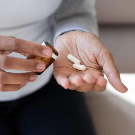 Person pouring pills out of a bottle into their hand