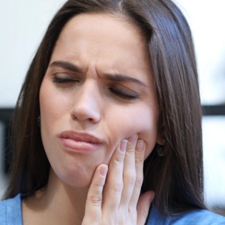 Woman holding her jaw in pain