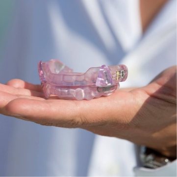 Dentist holding a light purple occlusal splint tray